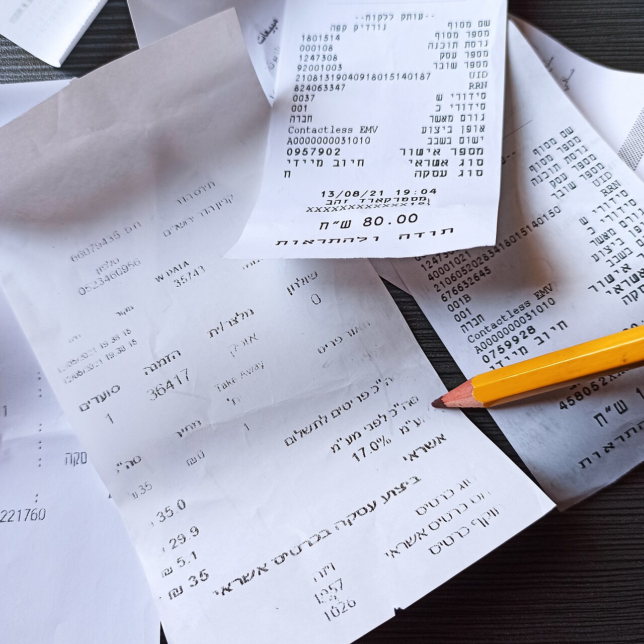 A group of printed receipts with a pencil